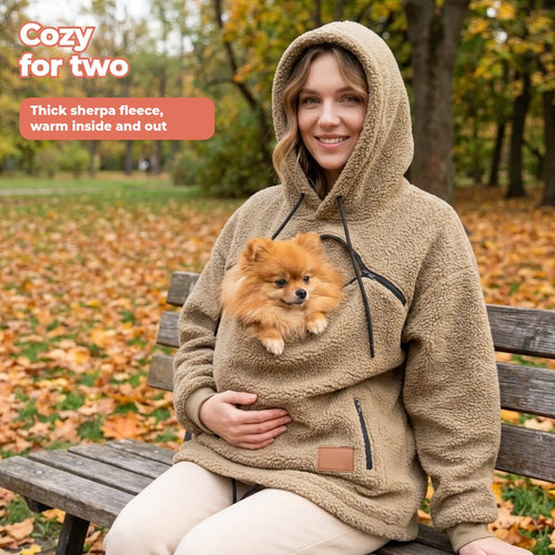 Khaki sherpa pet pouch hoodie with a Pomeranian in the chest pouch on a park bench