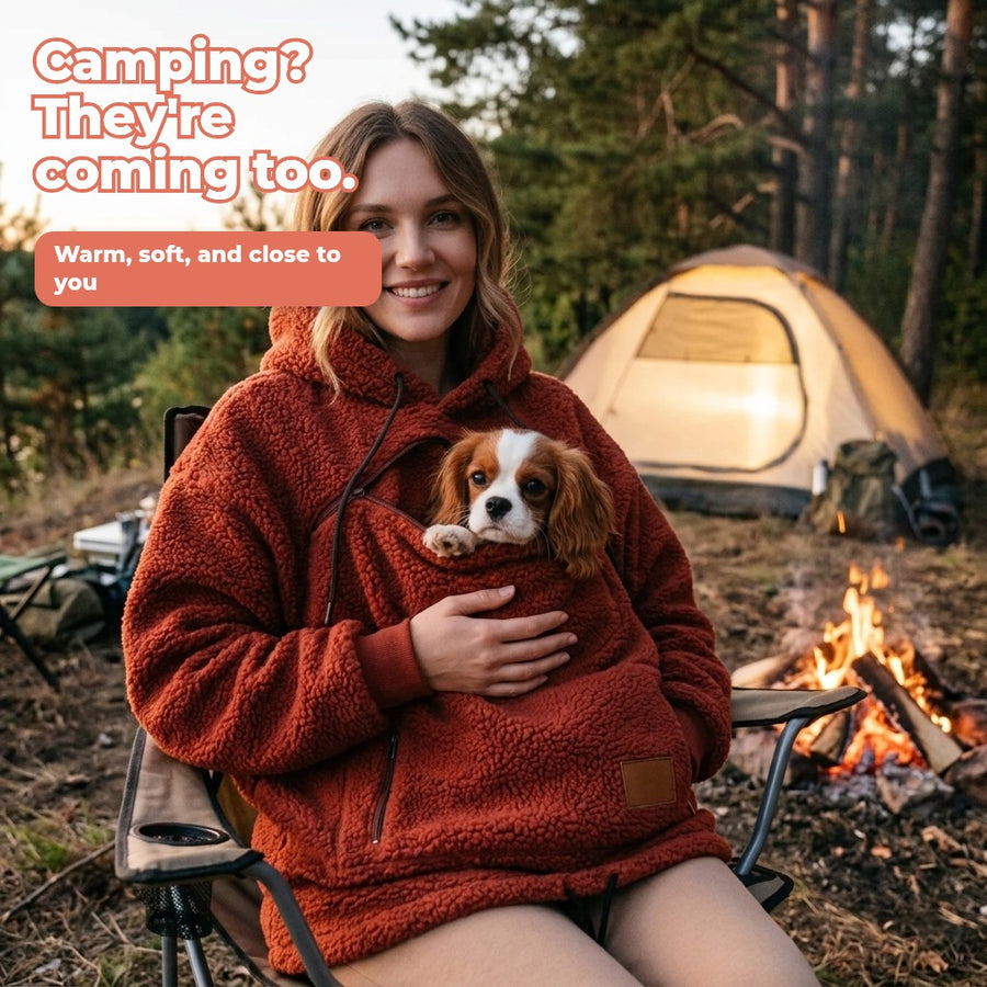 Brick red sherpa pet pouch hoodie with a Cavalier at a campsite